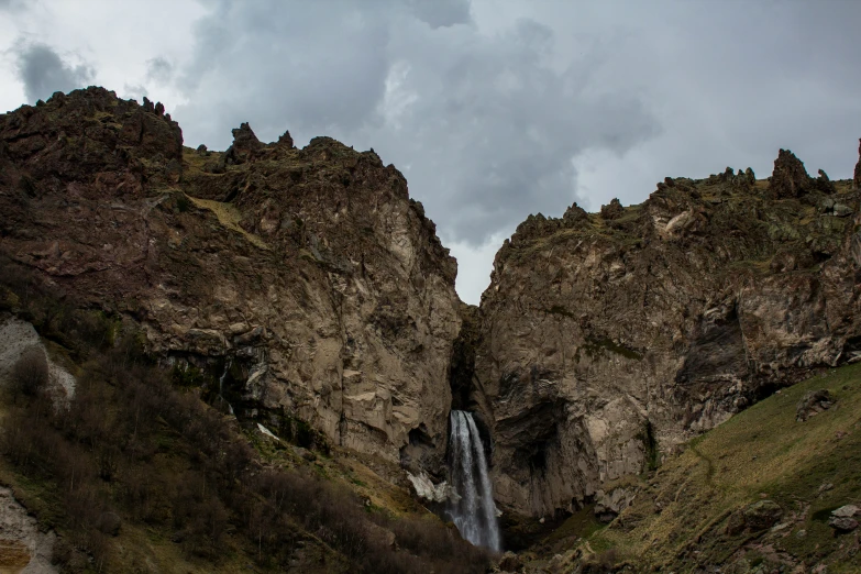 there is a waterfall in the middle of mountains