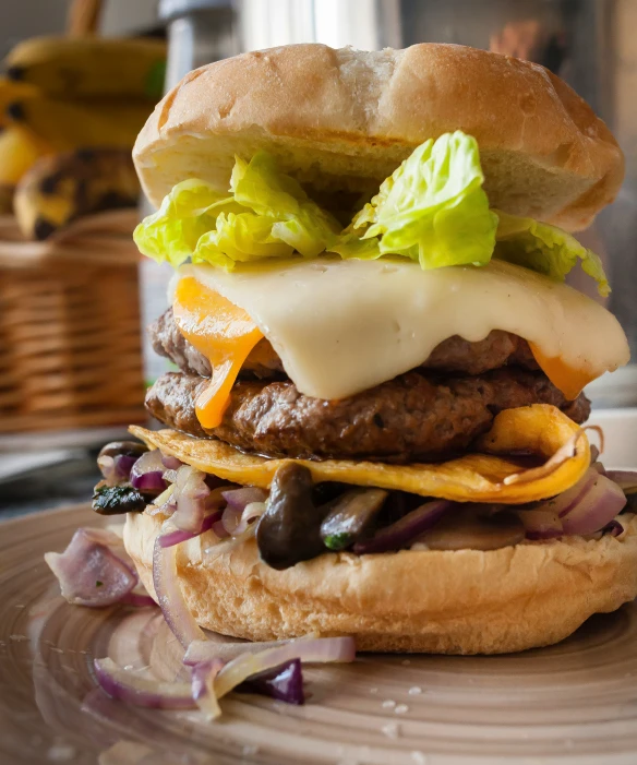 a large burger with lettuce, onions and cheese on it