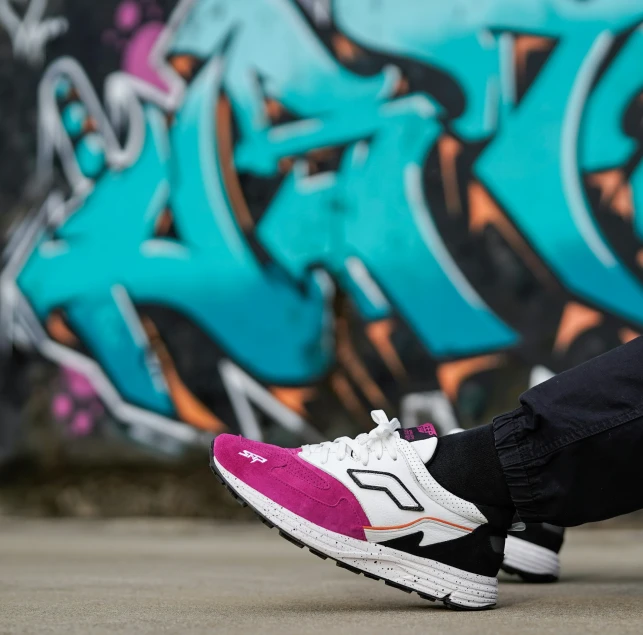 a woman is sitting against a graffiti covered wall