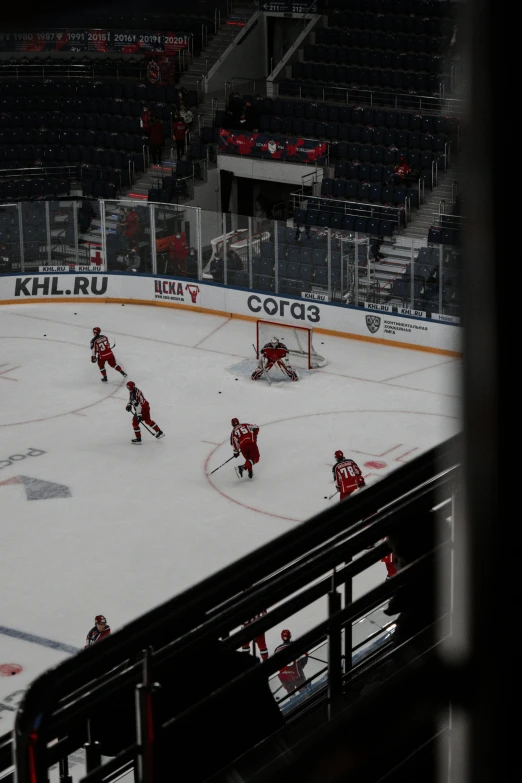 hockey players are on the ice as an audience watches