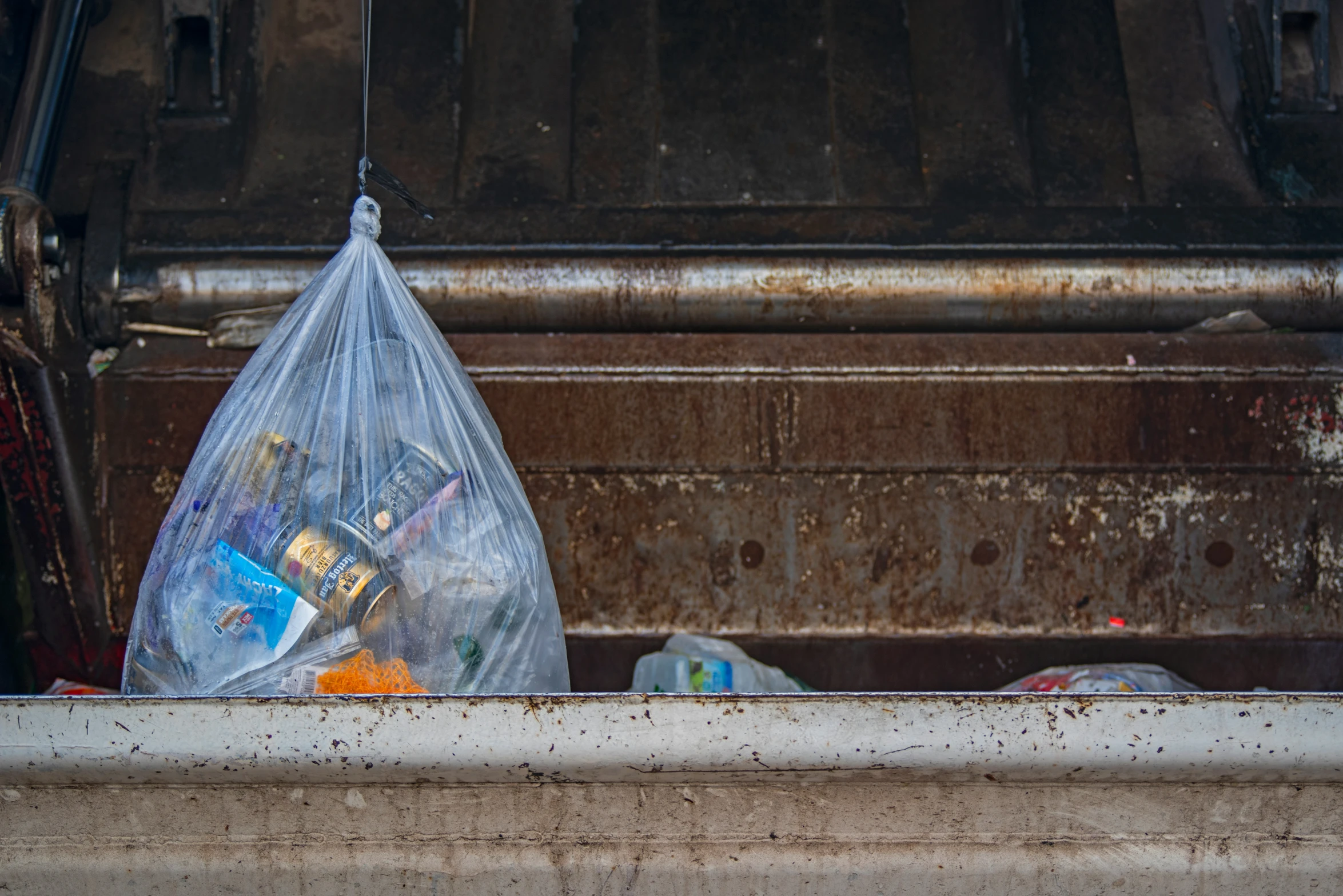 a garbage can full of items under a truck