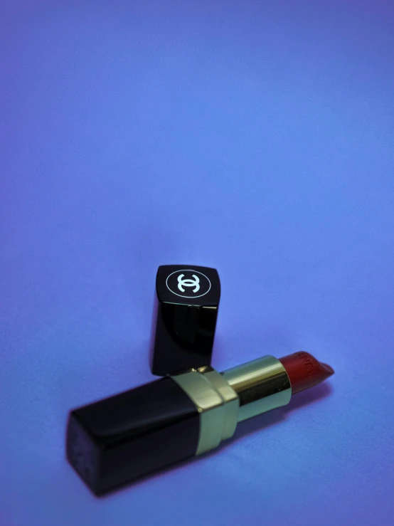 a lipstick and a golden lip on a purple background