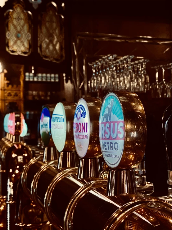 beer taps on the bar lined with glasses and hanging from the ceiling