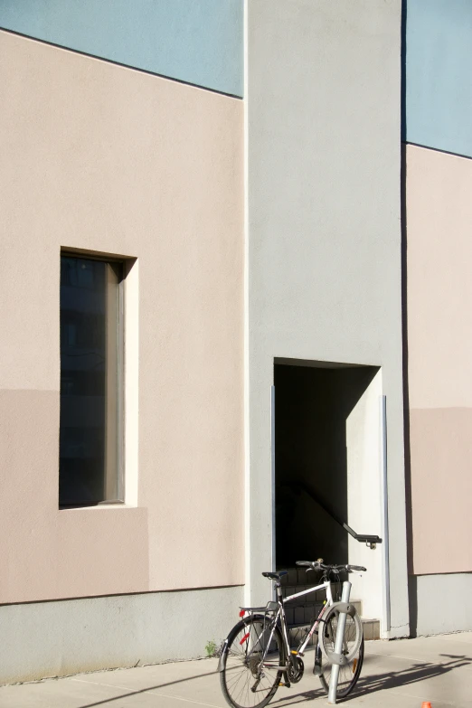 a bicycle parked next to an entrance of a building