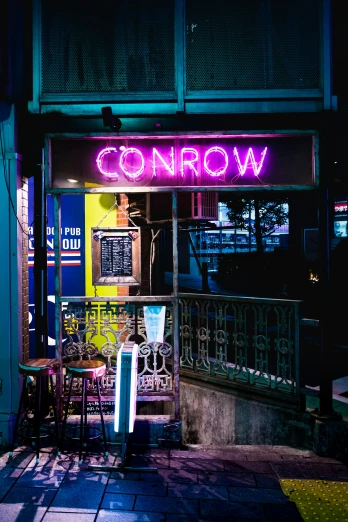 a neon sign in front of a small restaurant