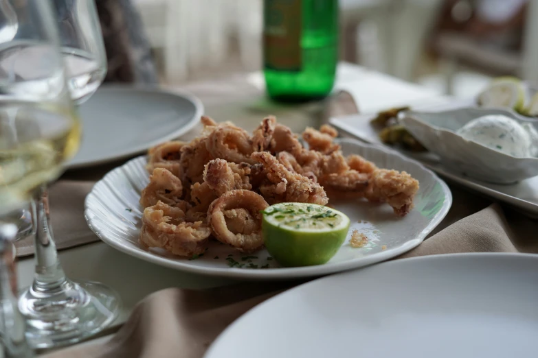 a plate topped with fried shrimp and a lime wedge