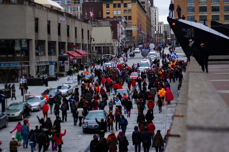 people walking in a busy city street with tall buildings