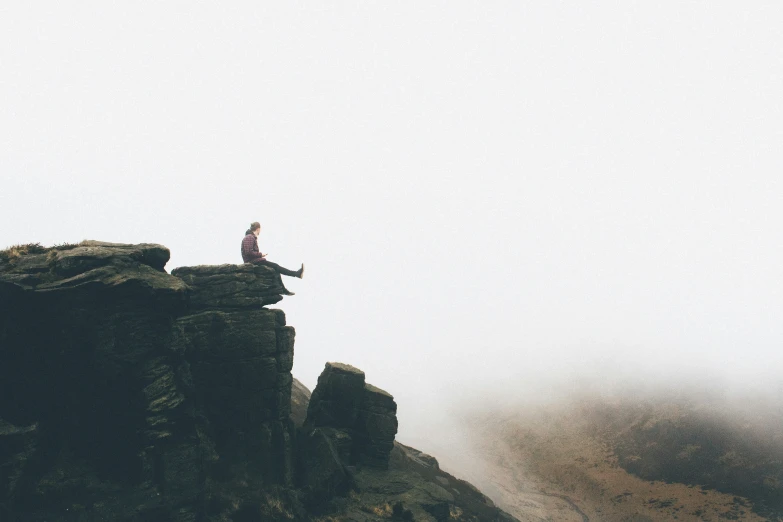 the man is standing on top of a mountain peak