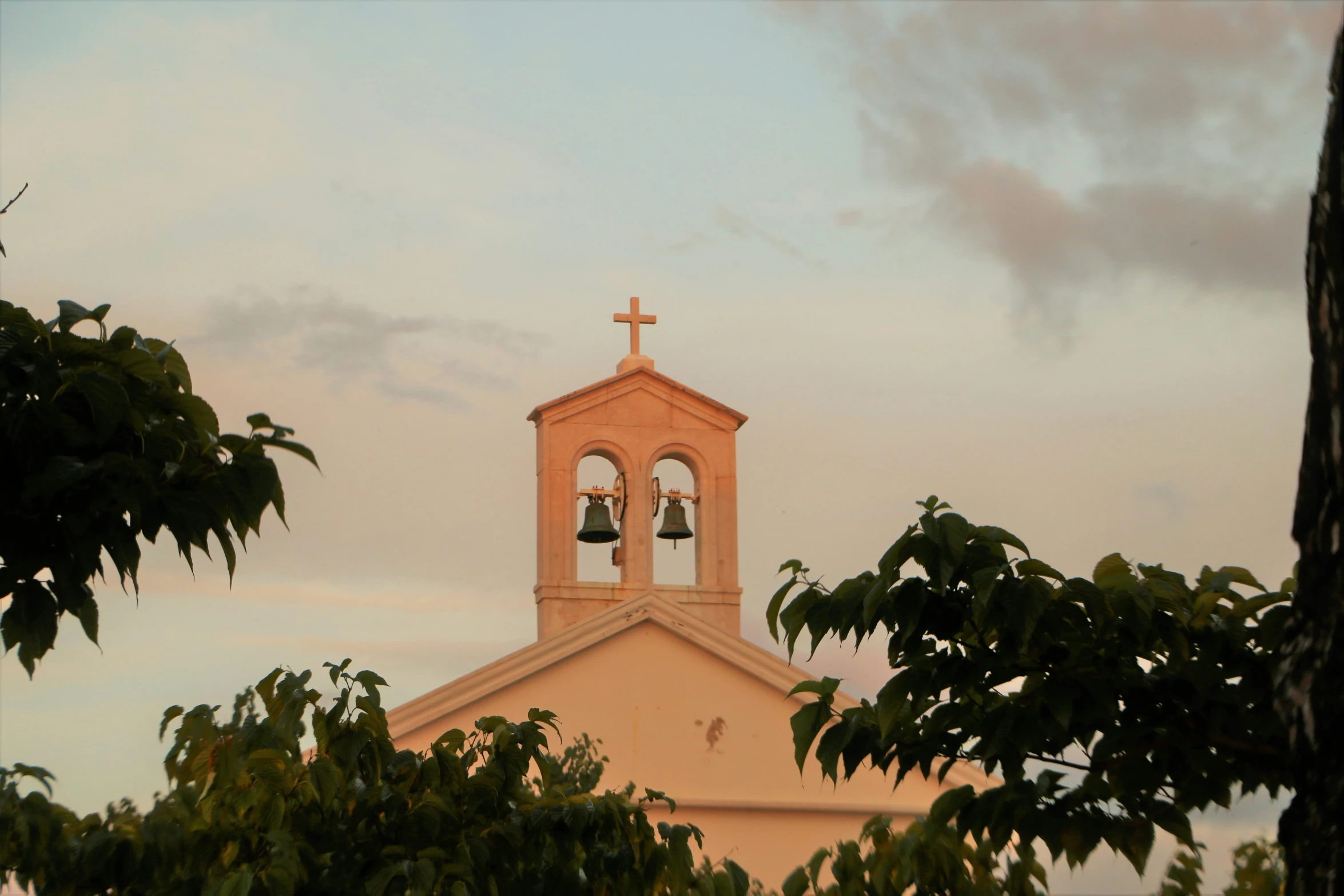 an old church with two bells on the roof