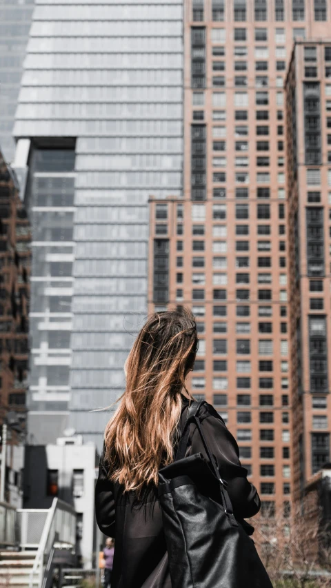 a woman walking through a city during the day