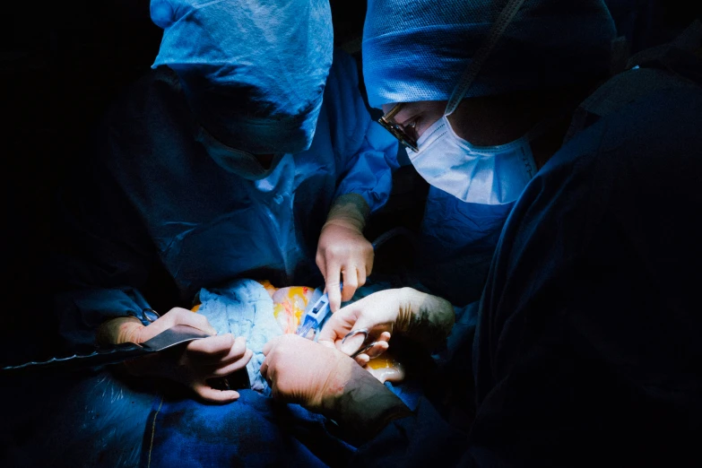 medical workers examine a child's stomach during an operation