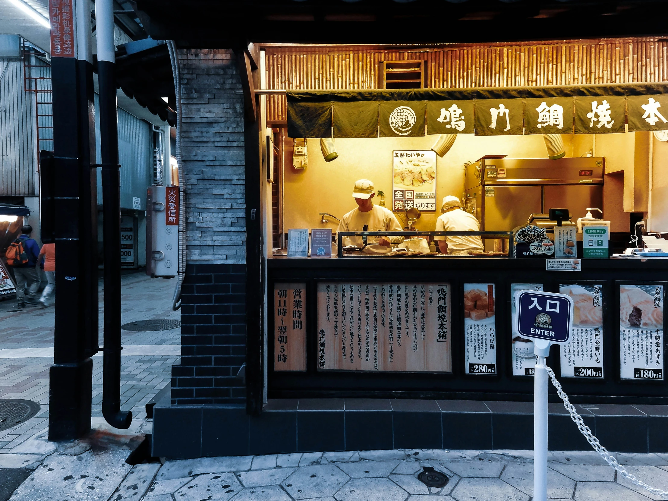 a restaurant window with people in it at night