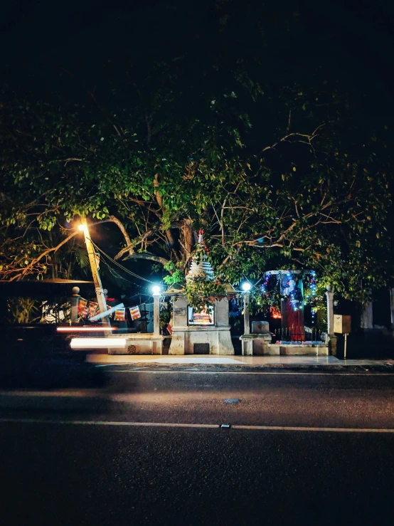 a bus is parked next to a bench under some trees