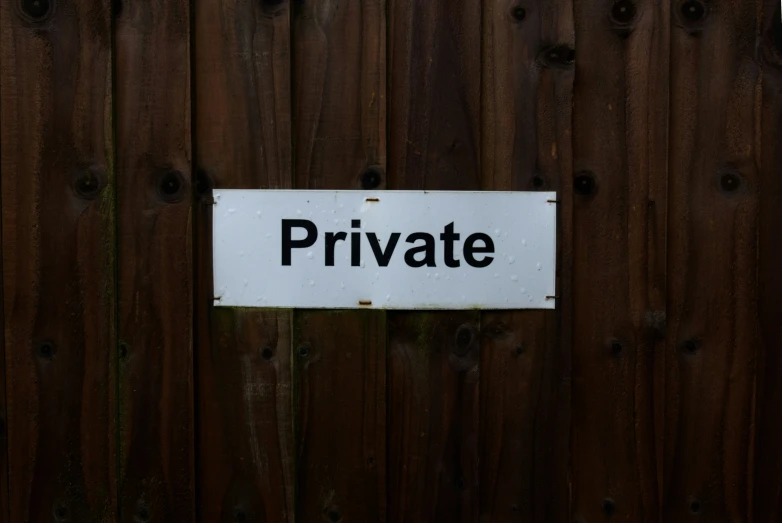 a sign that says private on a wooden wall