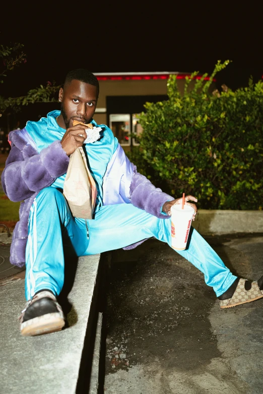 man in blue and white outfit sitting outside in the dark