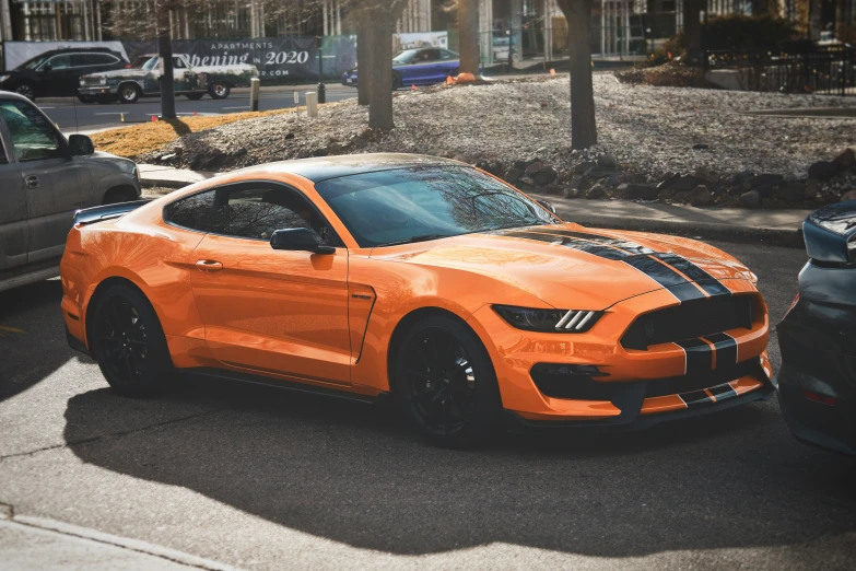 an orange car parked in front of a curb