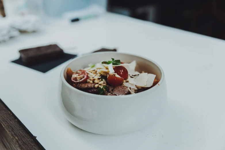 a white bowl full of different types of food on a table