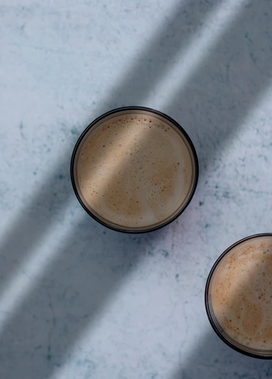 two coffee cups sitting side by side on a table