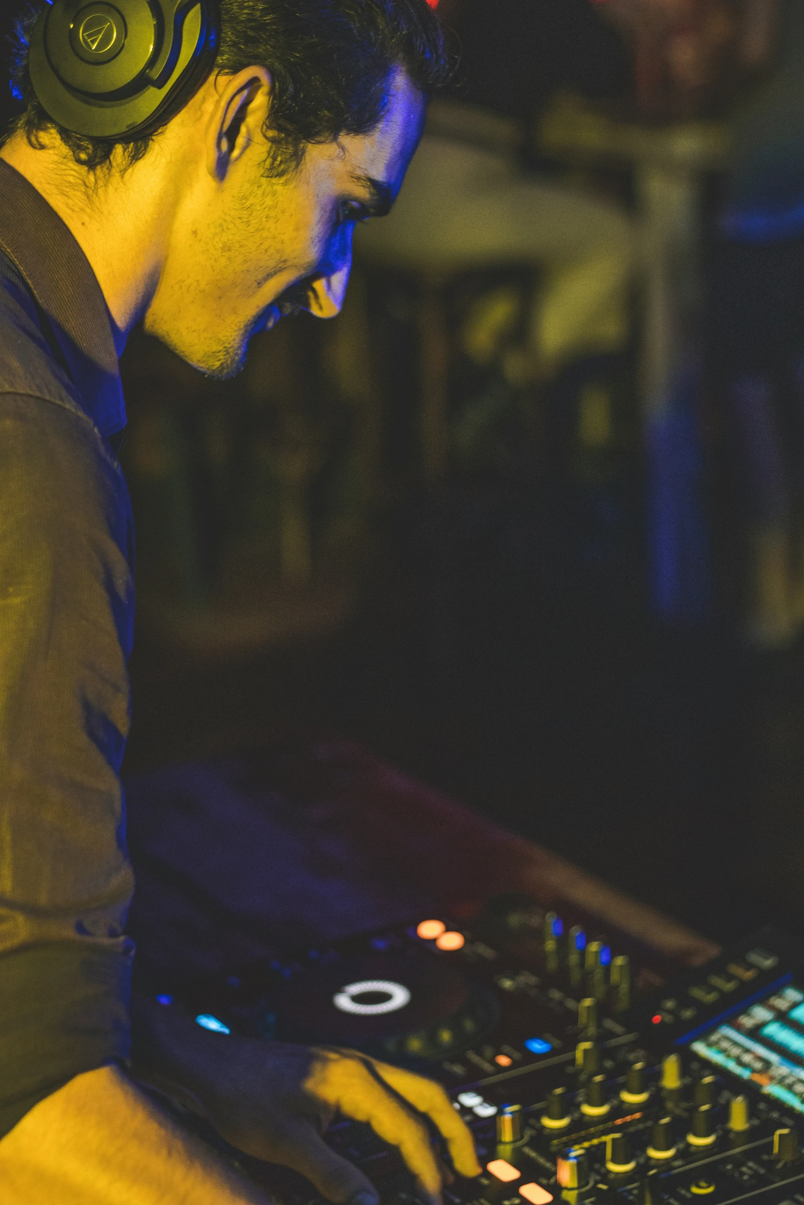 dj using mixing board with headphones on at party
