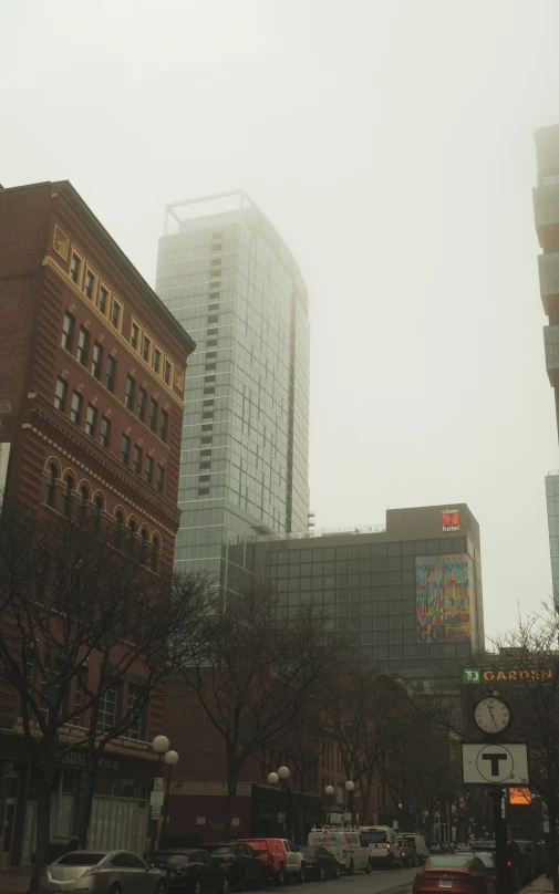 a foggy city street with tall buildings