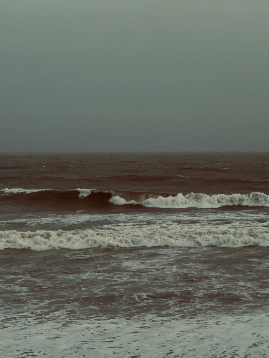 a boat in the middle of a body of water with waves