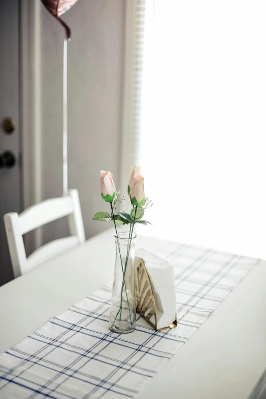 a vase with some flowers and books sitting on a table