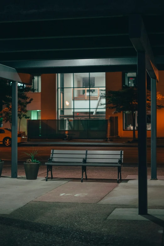 a dark picture of two park benches and a streetlight in the background