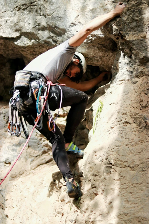 man climbing up a steep rock on a high mountain