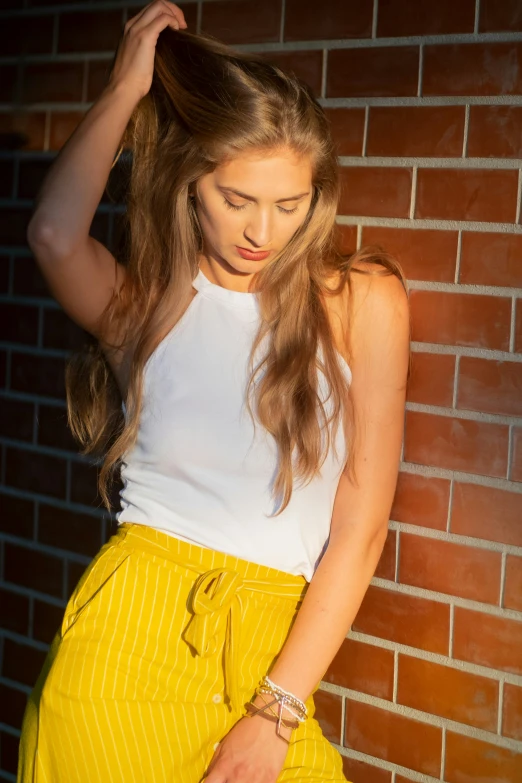 a woman with long hair wearing a yellow skirt and white top