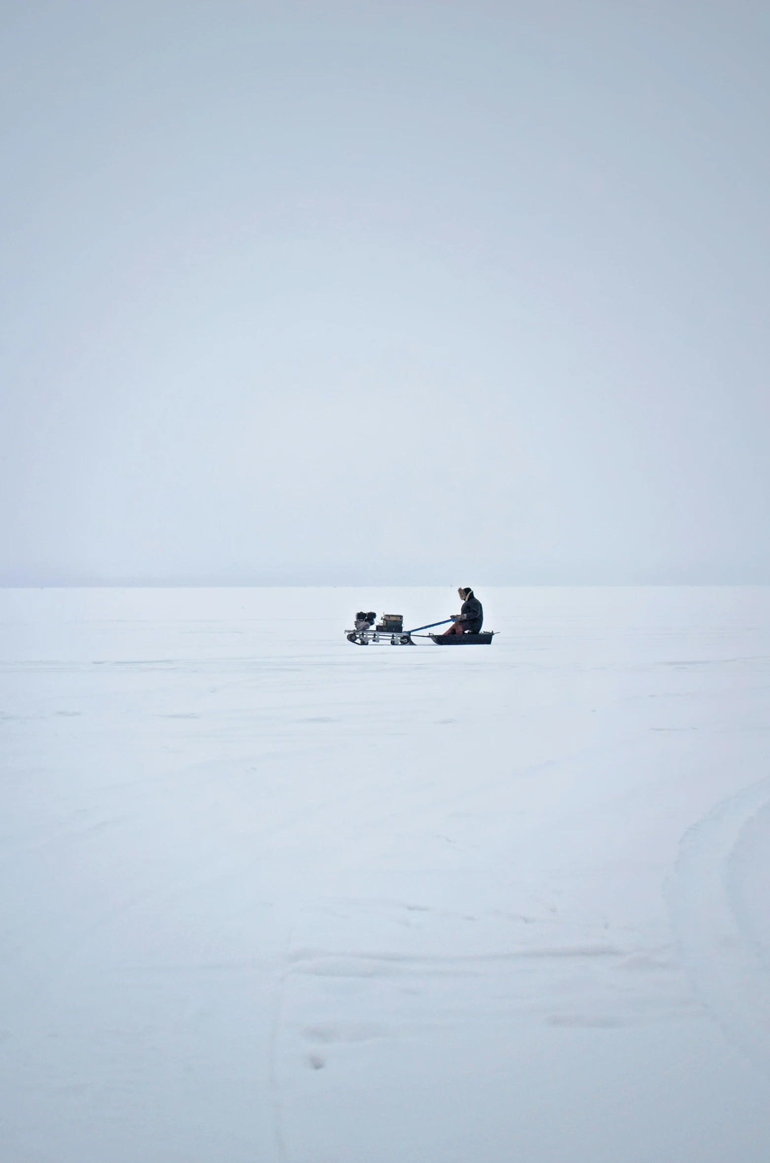 an ice fishing boat is traveling across a frozen lake