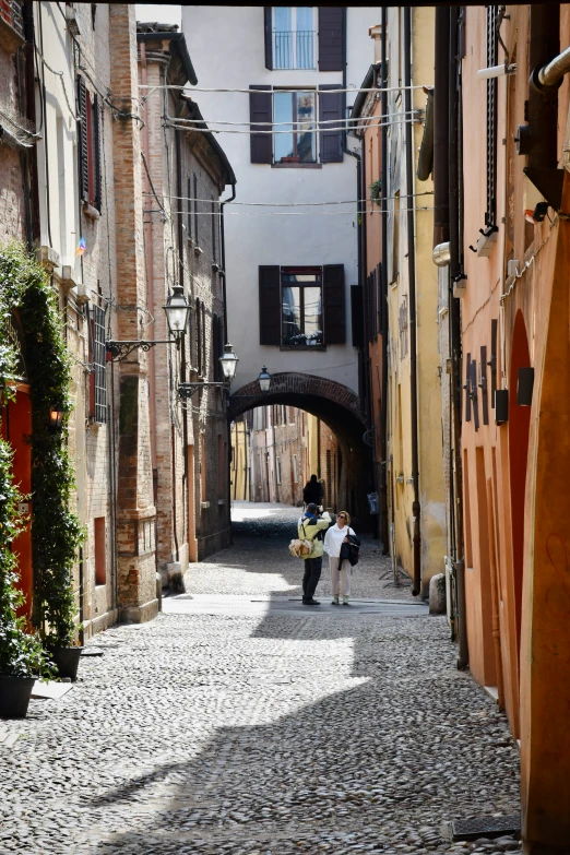 two children are walking down the cobblestone streets of a village