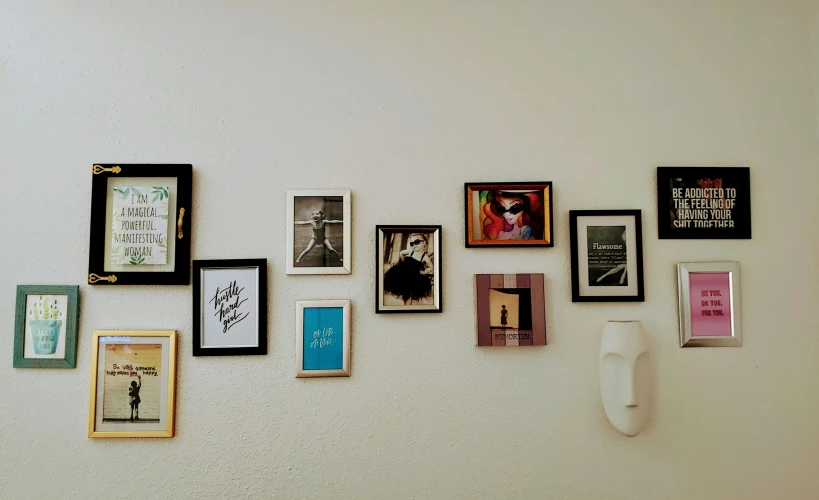 there is a wall that has several different pieces of art on it