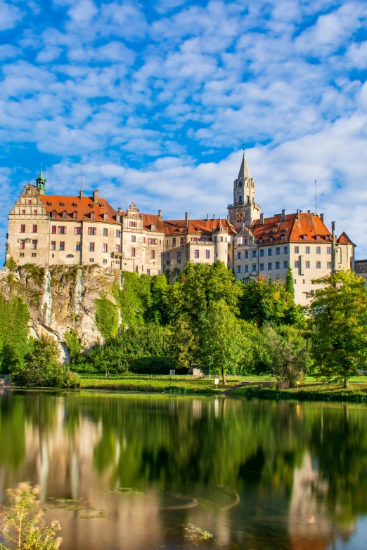 a large castle with red roofs sitting on top of a hill