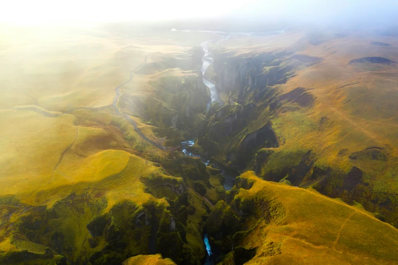 view of river and green mountains with a foggy sky