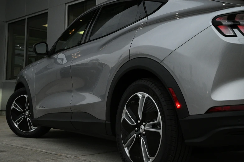 a silver, all electric vehicle is seen from the back