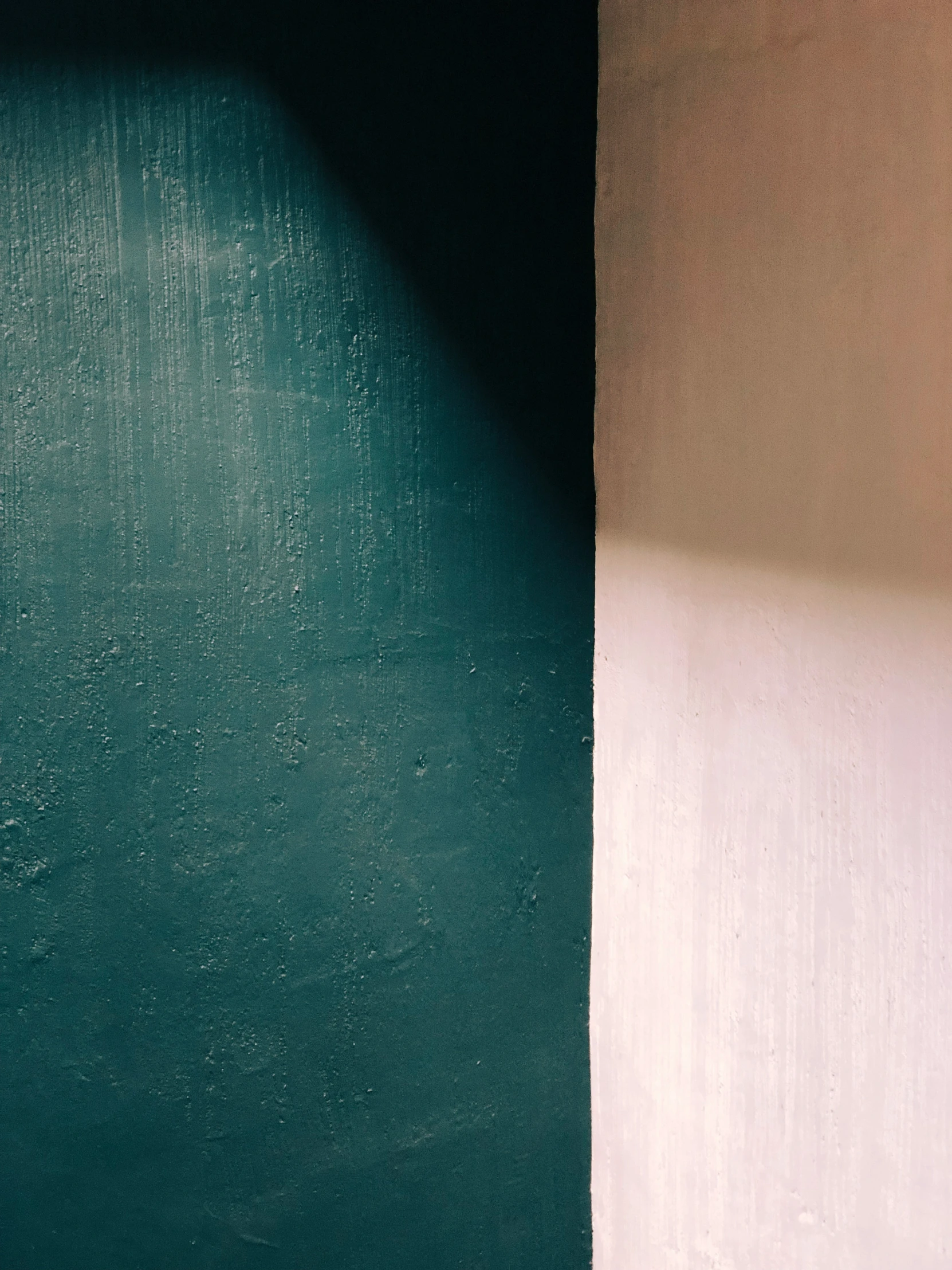 a clock sitting next to a white wall and a green door