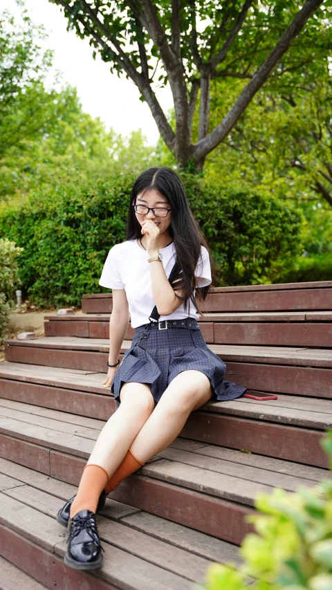 a woman sits on the steps while talking on her phone