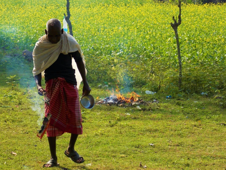 man walking through a field on his phone