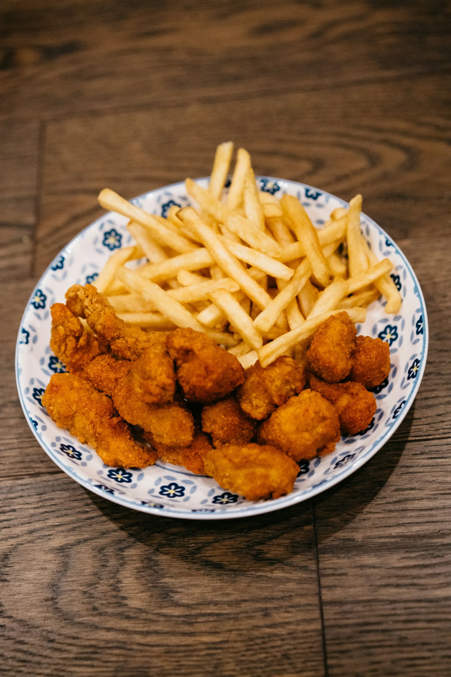 the chicken sticks are on the plate, and fries are on the plate