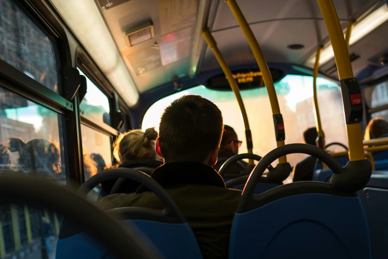 people are sitting on the bus and looking out the window