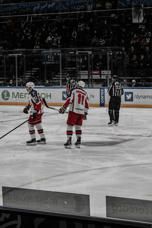 three hockey players in red and white are holding their sticks on the ice