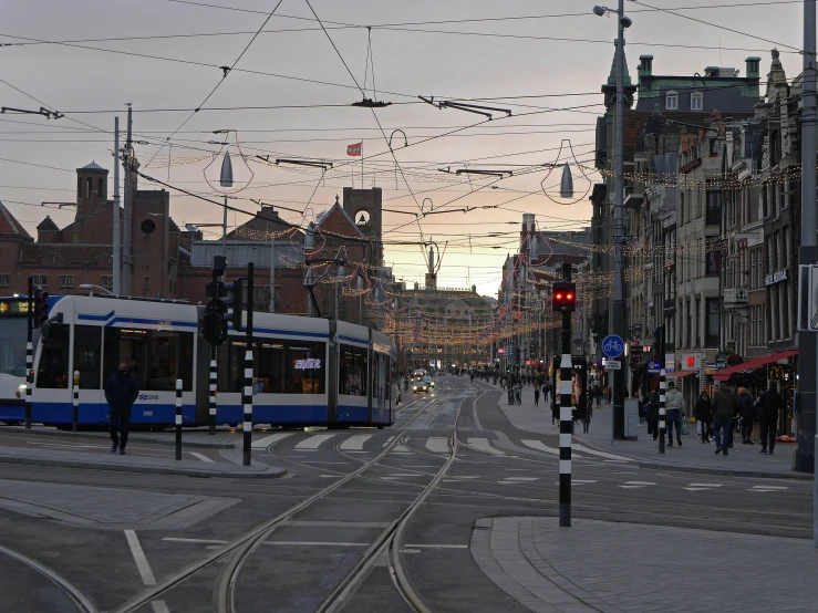 people walking on street with cars and wires above