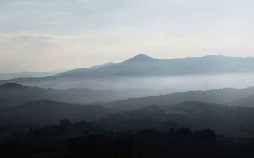 some mountains are in the distance with fog in them