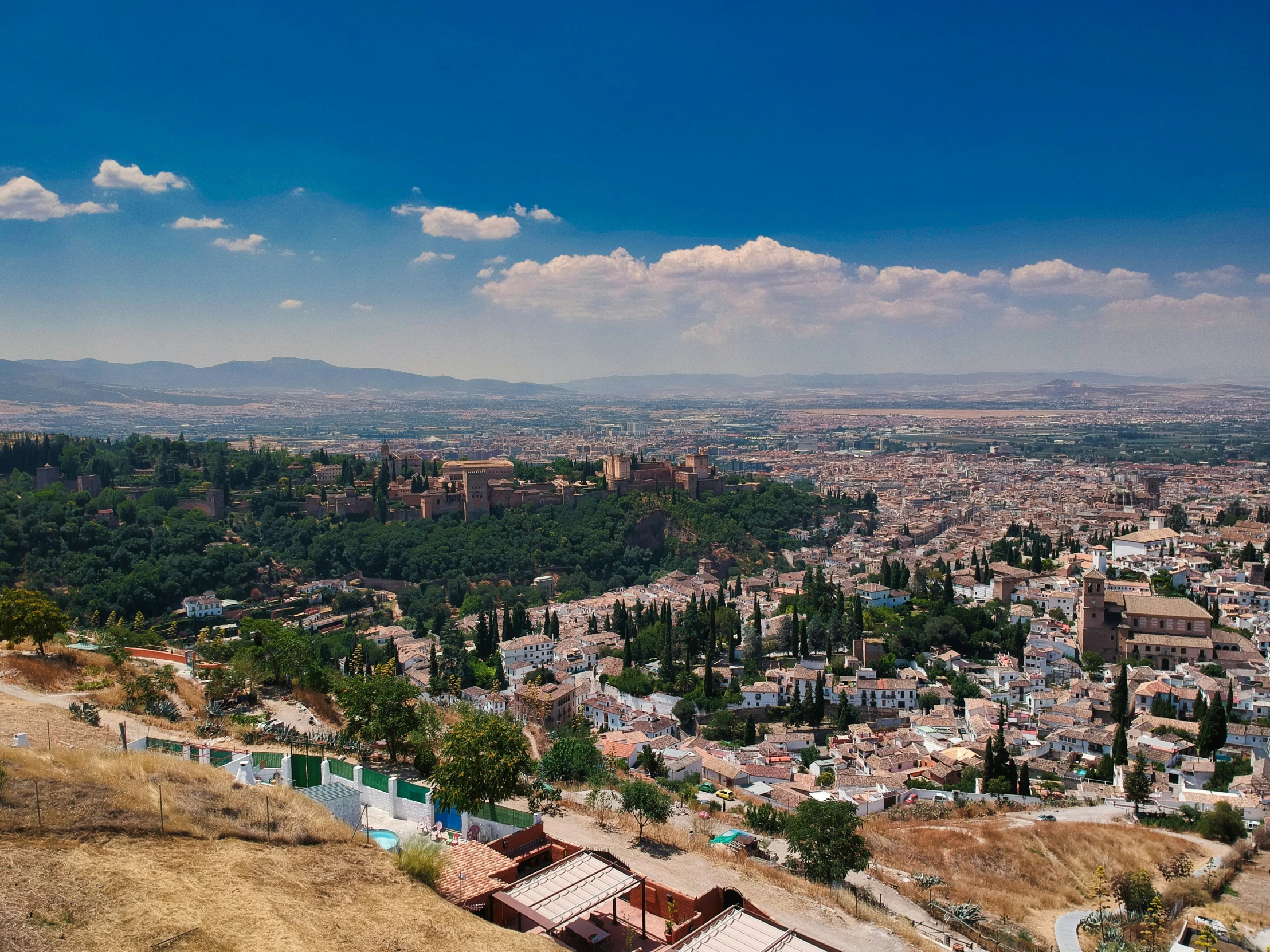 a view of a hill overlooking a city from top of a hill