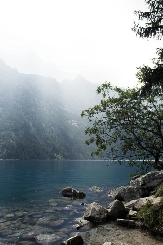 a view of a calm mountain lake with a lone boat on it