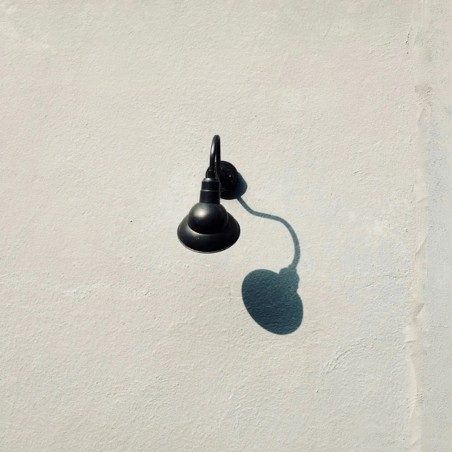 the side view of an old style street lamp casting a shadow