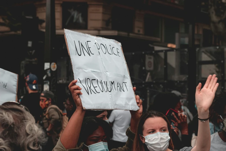 a group of people with masks on are protesting