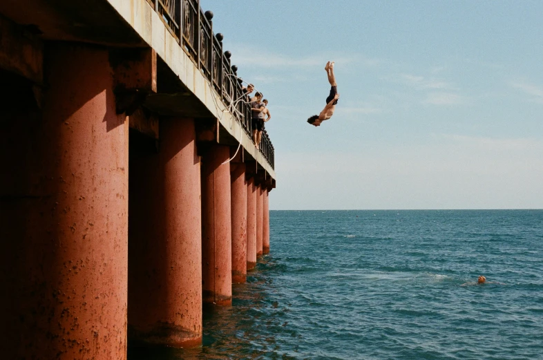 a person that is swimming in the water by a long pier