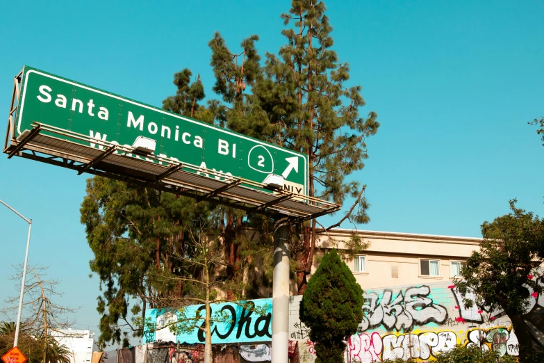 a city street sign hangs from a overpass