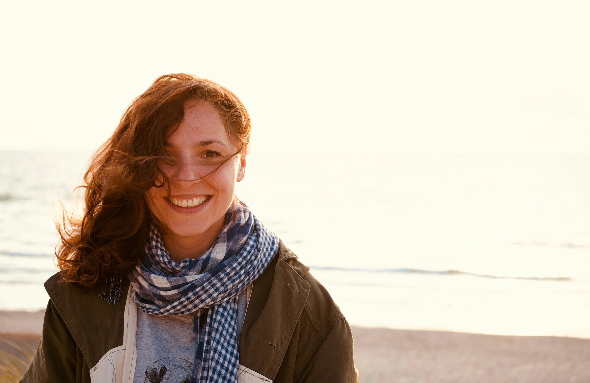 a woman smiling with her scarf around her neck